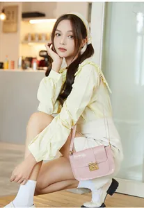 Vue détaillée du sac à main rose gaufré crocodile avec fermoir abeille dorée chic