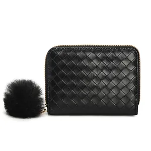 Black woven leather short wallet with gold zipper and decorative faux fur pompom charm