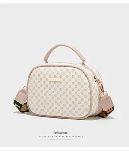 Detailansicht der weißen Muschel-Tasche mit Gold-Hardware und buntem Gurtband