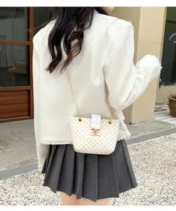 Detail of white chain bucket bag with yellow circular pattern and gold buckle