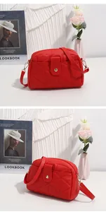 Macro shot of red quilted crossbody bag with golden hardware and triangle buckle