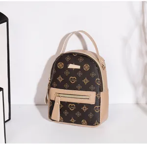 Detail van mini-rugzak met hartpatronen en ritsvak aan de voorkant in bruin en beige