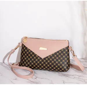 Dettaglio di una borsa a tracolla bicolore con patta rosa e motivo floreale marrone chic