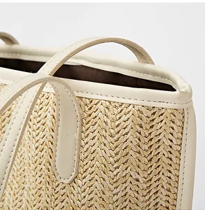 Detail view of woven herringbone straw texture with smooth cream leather trim and neat stitching