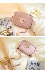 Détail du sac bandoulière rose à texture crocodile avec fermoir métallique en forme d'abeille