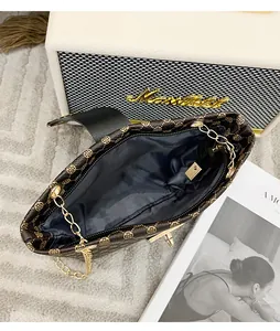 Top view of bucket bag interior with dark grey lining and golden chain strap detail