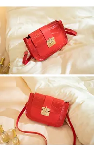 Vue détaillée du cuir texture crocodile rouge et de la boucle d'abeille dorée