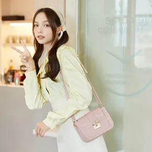Sac à bandoulière rose texture crocodile avec boucle abeille portée par un mannequin