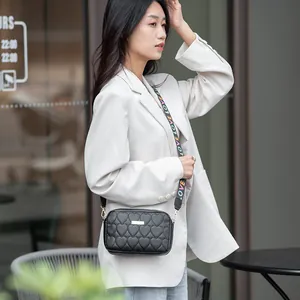 Black heart-quilted crossbody camera bag with a colorful 'LOVE' patterned wide strap