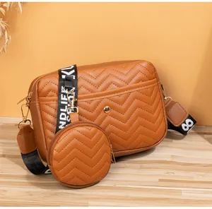 Détail du sac bandoulière marron caramel avec texture en V et petit porte-monnaie