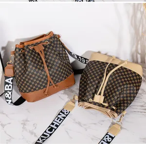 Détail de sacs seaux à cordon avec motifs monogrammes et bandoulières tissées colorées