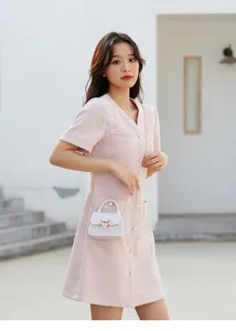 Nahaufnahme einer weißen Mini-Gelee-Tasche mit Kette auf rosa Tweed-Kleid für Damen