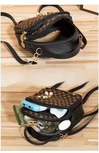 Detailed view of mini crossbody bag with pearl accents and triple zipper compartments