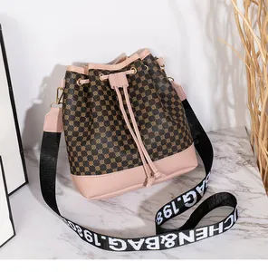 Détail du sac seau à cordon avec motif circulaire et glands en cuir rose décoratifs