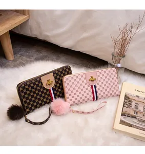 Detailed view of long zip wallets with vintage patterns, bee metal buckle, and fur pompom