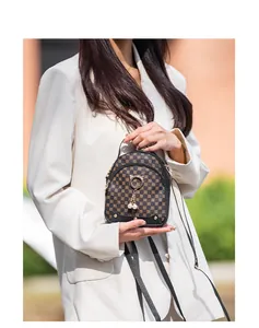 Outdoor street shot of a mini contrast pattern bag with cat-ear gold rings and pearls