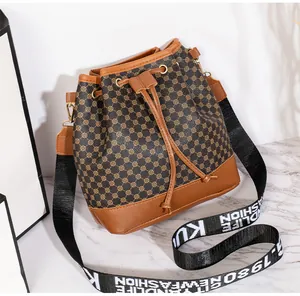 Détail du sac seau rétro avec motifs circulaires et large bandoulière en toile lettrée