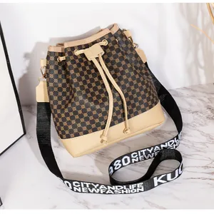 Détail d'un sac seau à cordon avec motifs géométriques et bandoulière en toile
