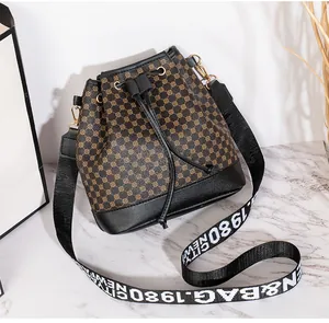 Détail du sac seau à cordon avec motif cercles et large bandoulière à lettres