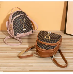 Detailed view of mini backpacks with golden cat-ear rings and pearl tassel accents