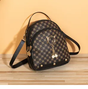 Close-up of mini backpack with vintage pattern, cat ear metal rings, and pearl tassels
