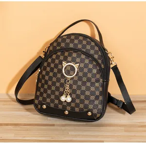 Detail of mini backpack featuring retro pattern, golden cat ears, and white pearl charms