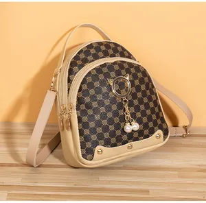 Detail of mini backpack with vintage pattern, golden cat ring and pearl charm
