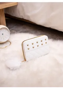 Detailed view of white quilted PU leather wallet with gold studs and plush pom-pom