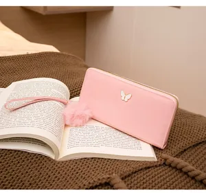 Portefeuille long rose pour femme avec fermoir papillon et pompon en peluche