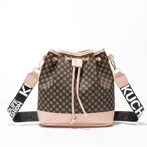 Sac seau monogramme marron avec garniture rose et bandoulière tissée à lettres