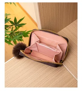 Dettaglio del portamonete multistrato in pelle marrone con fodera rosa chic