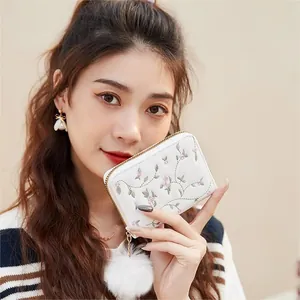 White embroidered small zipper wallet with pink flowers and a white pompom charm