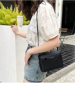 Sac bandoulière noir tendance avec découpes circulaires et détails de logo imprimé