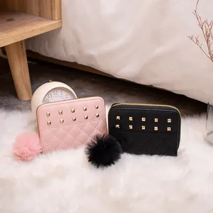 Quilted small wallets with metal studs and pompom charms in pink and black colors