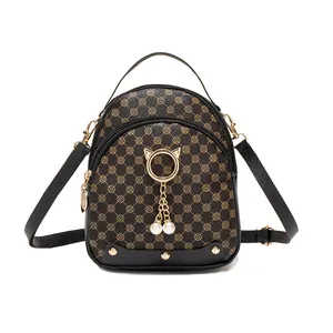 Mini backpack with clover pattern, cat-ear metal ring, and pearl charms on white background