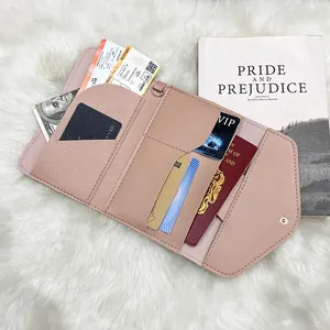 Pink faux leather passport wallet with multi-card slots displayed on a plush white background