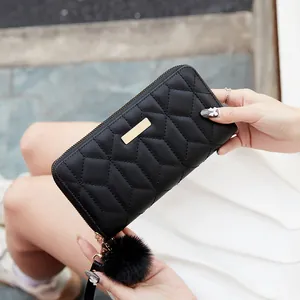 Portafoglio lungo nero da donna con ricamo a V, barra dorata e pompon di pelliccia