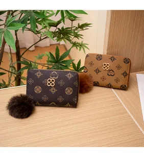 Dettaglio di portamonete vintage con pompon di pelliccia e chiusura a trifoglio in metallo