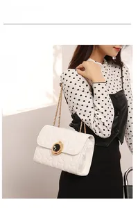 Détail du sac blanc à surpiqûres étoilées avec chaîne dorée et fermoir lune céleste