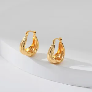 Vue macro détaillée de boucles d'oreilles gouttes dorées avec poinçon en argent 925