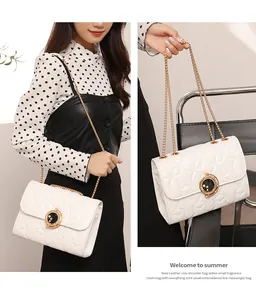Détail du sac blanc matelassé à broderie étoile, chaîne dorée et boucle lune star