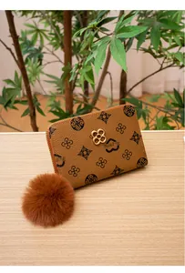 Portafoglio in pelle marrone con grana litchi, motivi floreali vintage e grande pompon