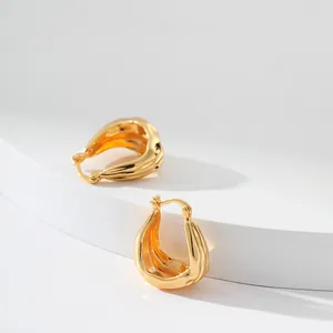 Vue détaillée de boucles d'oreilles goutte d'or 18 carats avec texture ondulée chic