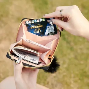 Portamonete in pelle nera con pompon decorativo e scomparti per carte a fisarmonica