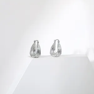 Vue détaillée des boucles d'oreilles goutte lave argentée avec texture métallique