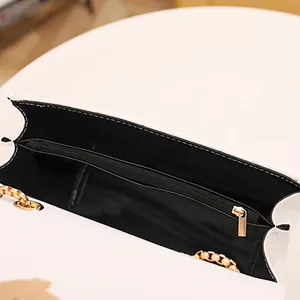 Vue intérieure du sac bandoulière blanc brodé d'étoiles avec doublure noire et chaîne dorée