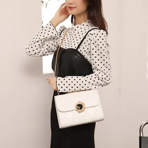 Sac bandoulière blanc matelassé avec fermoir étoile lune porté par un mannequin chic