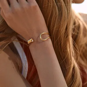 Detail of 18K gold plated brass cuff bracelet with spiral texture on model's wrist