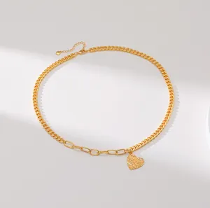 Goldene asymmetrische Halskette mit zerknittertem Herzanhänger und Zirkonia auf weißem Grund