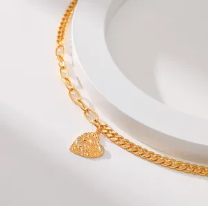Goldene Herz-Halskette mit Faltenstruktur und Zirkonia an gemischter Gliederkette